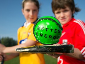 2 children playing GAA with a sliotar that says Better Energy